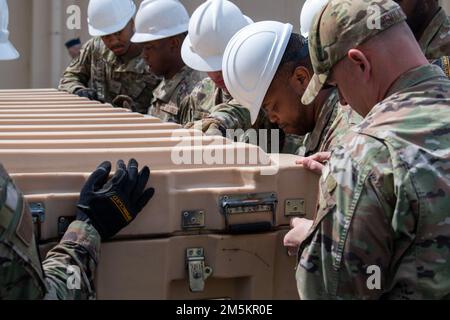 Deployed Airmen from the 117th Civil Engineer Squadron, Sumpter Smith Joint National Guard Base, Alabama, and the 908th CES, Maxwell Air Force Base, Alabama, close the cargo box lid that contains all of the former COVID-19 testing tent parts during its dismantling at Yokota Air Base, Japan, March 23, 2022. The two assisting CES teams were on a rotational deployment to help Team Yokota with larger construction projects, including the removal of the testing tent. Stock Photo