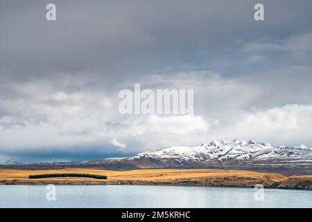 Scenic view of Lake Tekapo east bank. Beautiful view driving along the Lilybank Road from Lake Tekapo Park towards Motuariki View Point. Stock Photo