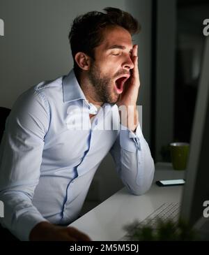 Putting in the hours to achieve success. a young businessman working late at the office. Stock Photo