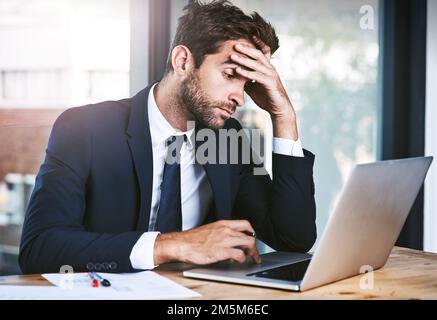 This just isnt working...a handsome young businessman looking stressed while working on his laptop in the office. Stock Photo