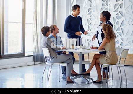 Sharing is business expertise. a group of colleagues working together in an office. Stock Photo