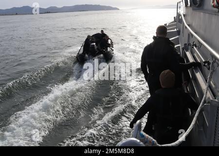 Green Berets with 2nd Battalion, 1st Special Forces Group (Airborne) cling to a Coast Guard vessel with the United States Coast Guard Station Cape Disappointment during vehicle board, search and seizure training, March 24, 2022. The training better prepared the Green Berets to perform maritime operations on the open ocean in the Indo-Pacific region. Stock Photo