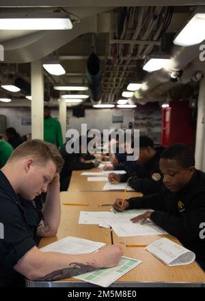 Sailors assigned to USS Gerald R. Ford (CVN 78) participate in the Navy-wide advancement exam for E-5 candidates in Ford’s aft galley, March 24, 2022. Ford is underway in the Atlantic Ocean conducting flight deck certification and air wing carrier qualifications as part of the ship’s tailored basic phase prior operational deployment. Stock Photo