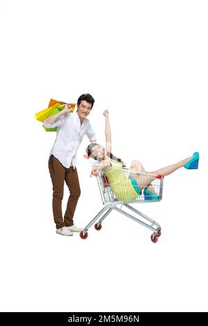 Shed on fashion shopping dynamic young couples pushing a shopping cart Stock Photo