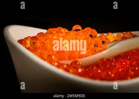 Salmon caviar in a bowl on a mother of pearl spoon Stock Photo