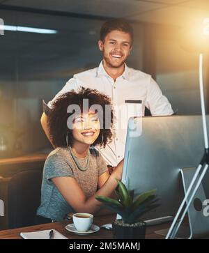 The two of us are going places. young employees working late into the evening. Stock Photo