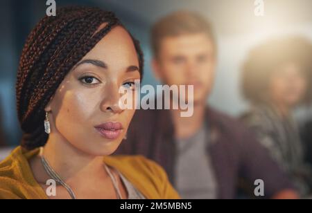 Well work through the night if thats what it takes. Cropped portrsit of a young woman working late with her colleagues in the office. Stock Photo