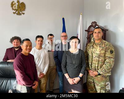 U.S. Army Soldiers assigned to the 1st Battalion, 5th Field Artillery Regiment, 1st Armored Brigade Combat Team, 1st Infantry Division, and staff members of the High School No. 10 of Torun pose for a photo after a meeting in Poland, March 25, 2022. The Soldiers visited the high school to meet the students, play a friendly basketball game, and sit with them in a classroom to talk about their mission and answer general questions to strengthen the U.S.-Polish community relations. Stock Photo