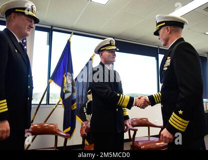 BATH, Maine (MARCH 25, 2022) -- U.S. Navy Vice Adm. William Galinas, Commander Naval Sea Systems Command, center, congratulates Capt. David Hart on taking over command of SUPSHIP Bath from Capt Joe Tuite, left. U.S. Navy photo by Chief Mass Communication Specialist Roger Duncan Stock Photo