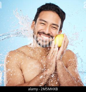 Skincare, water and portrait of man with a lemon in studio for healthy, organic and natural face routine. Health, wellness and man from India with Stock Photo