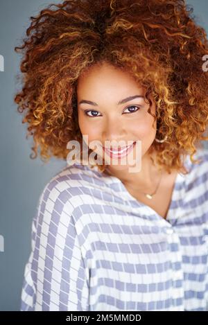 Full of self confidence. Studio shot of a young businesswoman against a gray background. Stock Photo