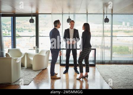 Three heads are better than one. three businesspeople talking in a corporate office. Stock Photo