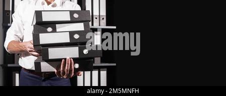Business banner. Office worker holding many accounting documents, folders binders stack in hand with copy space for text. High quality photo Stock Photo