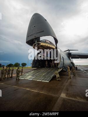 U.S. Airmen with the 22nd Airlift Squadron, Air Mobility Command, lower the loading ramp on a Lockheed C-5M Super Galaxy at Royal Australian Air Force Base Darwin, NT, Australia, March 27, 2022. The C-5M transported U.S. Marine Corps equipment from Darwin to Okinawa, Japan, an initiative by Marine Rotational Force-Darwin 22, ensuring the equipment is operational to maintain a credible crisis and contingency-ready force that can contribute to a free and open Indo-Pacific region. Stock Photo