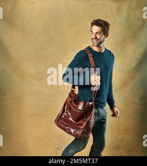 Handsome with a heart of gold. Studio shot of a handsome young man posing against a golden background. Stock Photo