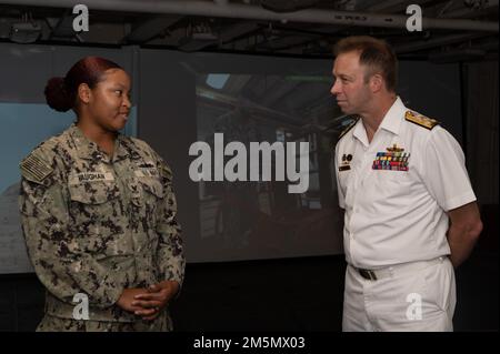 SYDNEY (March 28, 2022) – Gunner’s Mate 2nd Class Kendra Vaughan, assigned to the Emory S. Land-class submarine tender USS Frank Cable (AS 40), explains her job in weapons department to Royal Australian Navy Vice Adm. Michael Noonan, Chief of Navy Australia, during a tour of the ship, March 28. Frank Cable is currently on patrol conducting expeditionary maintenance and logistics in support of national security in the U.S. 7th Fleet area of operations. Stock Photo