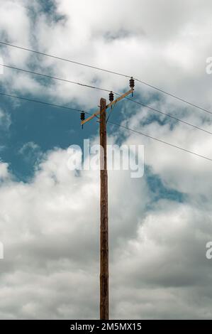 Vertical image of a utility pole against a cloudy sky Stock Photo