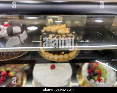 Montecito, California, U.S.A. 29th Dec, 2022. Black and Tan/gold 'Happy 2023 Cake'' appears blurred as it is displayed among others under a glass, at the Montecito Vons Bakery on Coast Village Rd., in Montecito, California on December 29, 2022. (Credit Image: © Amy Katz/ZUMA Press Wire) Stock Photo