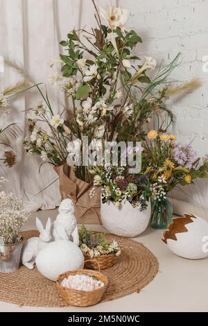 Interior floral Easter composition. Figurines of Easter bunnies and a large eggshell. The concept of home decoration for the Happy Easter holiday Stock Photo