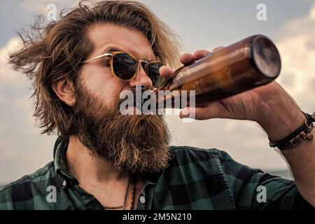 thirst. man drink from glass bottle. brutal man with water. refresh with water. bearded man wear checkered shirt. casual male relax while drinking Stock Photo