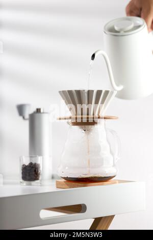 Pouring hot water through coffee grounds in a filter Stock Photo