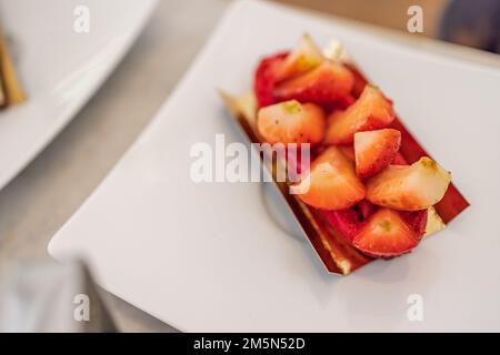 Sliced strawberries isolated on white background, selective focus, close-up shot in elegant luxury restaurant. Strawberry cake Stock Photo
