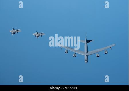 U.S. Air Force F-22 Raptors fly alongside a U.S. Air Force B-52H Stratofortress above the Arabian Gulf, March 29, 2022. The presence of the B-52H showcased U.S. Central Command's ability to deliver combat airpower at a moment's notice, as well as its commitment to partners and regional security. Stock Photo