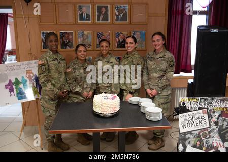 U.S. Soldiers assigned to 16th Sustainment Brigade, 30th Medical Brigade, 44th Expeditionary Signal Battalion, and civilians from the Baumholder Military Community observed Women's History Month with a cake-cutting ceremony at the Knights Lair Dining Facility, Baumholder, Germany, Mar. 29, 2022. Stock Photo