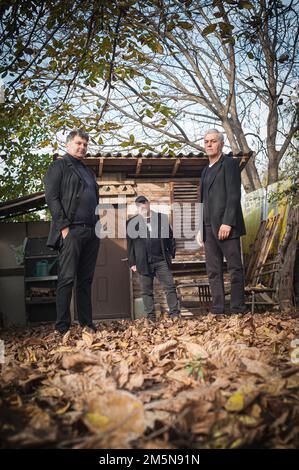 Portrait of urban and handsome fashionable artist guy pose in black elegant suits outdoor Stock Photo