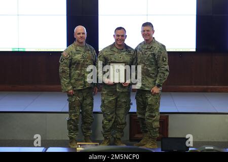 Staff Sgt. Samuel Lima, a squad leader with Bravo Troop, 1st Squadron, 75th Cavalry Regiment, 2nd Brigade Combat Team, 101st Airborne Division (Air Assault) (center), receives a Certificate of Appreciation from Maj. Gen. JP McGee, commanding general, 101st Abn. Div. (AA) (right) and Col. Ed Matthaidess, commander, 2nd BCT (left), during a cohesion roundtable brief at Fort Campbell, Ky., March 29, 2022. Lima developed a concept for Soldiers in his formation to use Eagle Tribe Time to have open discussions of issues, think critically, and build team cohesion. Stock Photo