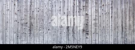 Grey weathered wooden wall made of vertical boards with strong grain Stock Photo
