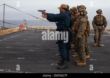 U.S. Marines with Echo Company, Battalion Landing Team 2/6, 22nd Marine Expeditionary Unit, provide coaching to Sailors while they execute a pistol range aboard San Antonio-class amphibious transport dock ship USS Arlington (LPD 24), March 28, 2022. Arlington and 22nd Marine Expeditionary Unit are on a scheduled deployment under the command and control of Task Force 61/2 in the U.S. Sixth Fleet area of operations. Stock Photo