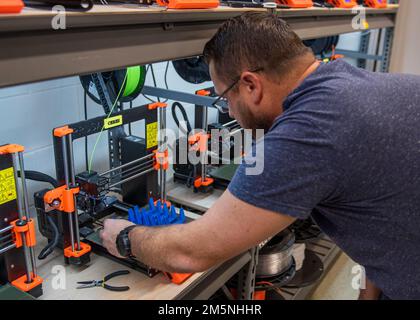 Additive Manufacturing Lab (AML) Head Chuck Self produces an innovation called the Laptop Lifter (aka the Tide Riser) engineered to extend the life of essential computer systems through improved cooling ventilation at Naval Surface Warfare Center Panama City Division on Feb. 9. Self can produce up to 240 units per day utilizing 10 or more Fused Deposition Modeling 3-D Printers. Stock Photo