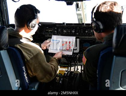 U.S. Air Force Capt. James Pyjas and Lt. Col. Charles Sendral, pilots assigned to the 105th Airlift Wing, go over potential simulated enemy threats during a flight training exercise over Syracuse, New York, Feb. 24, 2022. The training exercise was conducted in coordination with the 174th Attack Wing with the purpose of integrating dissimilar assets throughout the New York Air National Guard. Stock Photo