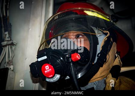 A sailor aboard the guided-missile destroyer USS Delbert D. Black (DDG 119) simulates fighting a fire during general quarters while underway for Surface Warfare Advanced Tactical Training (SWATT). Delbert D. Black is part of Destroyer Squadron (DESRON) 26 which supports Carrier Strike Group (CSG) 10. SWATT is led by the Naval Surface and Mine Warfighting Development Center (SMWDC) and is designed to increase warfighting proficiency, lethality, and interoperability of participating units. Stock Photo