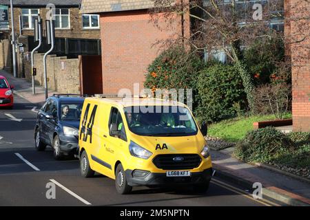 A SUNNY LANDSCAPE VIEW FROM ABOVE OF AN AA BREAKDOWN RECOVERY VAN TOWING A BROKEN DOWN CAR Stock Photo