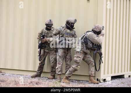 Spc. Garrett Witherspoon (left), an infantryman with Troop F, 2-278th Armored Cavalry Regiment, Tech. Sgt. Michael Samsa (center), a security forces airman with the 134th Security Forces Squadron, 164th Air Refueling Wing, and Sgt. Zachary Kleinfelder (right), an infantryman with Detachment 1, 2-278th Higher Headquarters Troop, stack on the side of a building during the Tennessee National Guard's 2022 Best Warrior Competition in Tullahoma on February 26. The competitors simulated conducting military operations in urban terrain (MOUT) in order to capture a high value target. Stock Photo