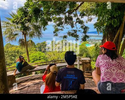 Khao Tut, Phuket, Thailand, Group Chinese Tourists,  People Visiting Tropical Island, 'Big Buddha', Woman from behind sitting on Bench Photographing Landscape with Smart Phones Stock Photo