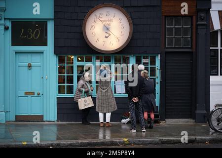 People stop to read the floral tributes which have been placed outside, Vivienne Westwood Worlds End shop in London, the fashion designer has died at the age of 81. Picture date: Friday December 30, 2022. Stock Photo