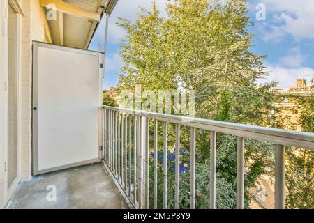 an apartment balcony with trees and blue sky in the background, taken on a sunny summer day photo by real estate photographer Stock Photo