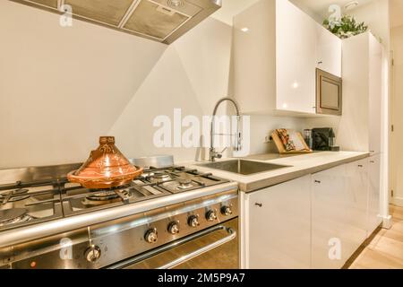 a kitchen with an oven, sink and dishwasher in the photo is taken from the front view window Stock Photo