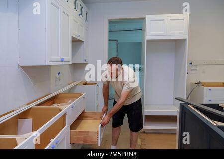 Working on kitchen cabinet draw in new home by carpenter Stock Photo
