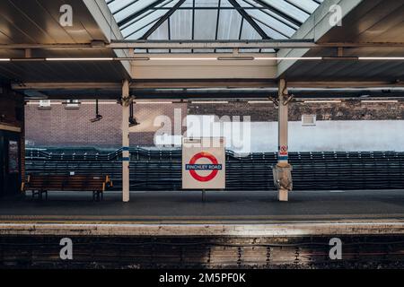 London, UK - December 26, 2022: Roundel name sign at the outdoor platform of Finchley Road station of London Underground, the oldest underground railw Stock Photo