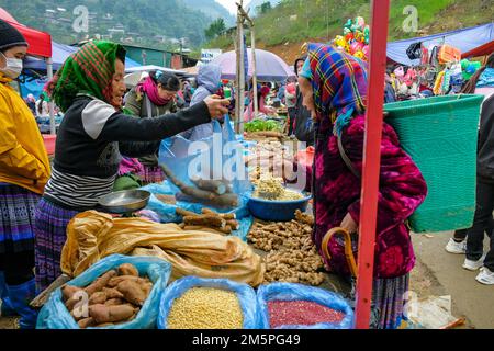 Can Cau, Vietnam - December 17, 2022: A vegetable vendor at Can Cau market in Lao Cai province, Vietnam. Stock Photo