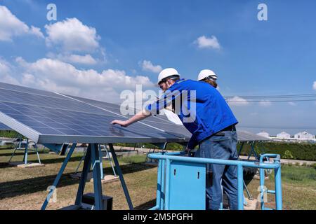 Maintenance engineer at solar farm stand on scissor lift routine inspection solar panel condition Stock Photo