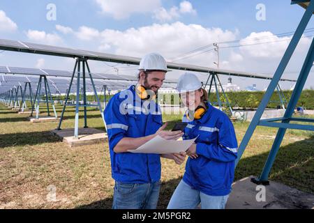 Engineer at solar farm on break time looking funny social media from mobile phone and laughing Stock Photo