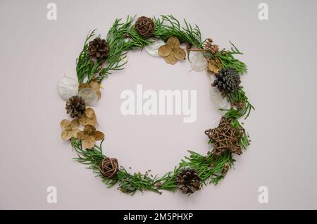 Christmas and new year festive round frame, card template with dried flowers, thuja branches, thuja buds and fir cones, flat lay, top view Stock Photo