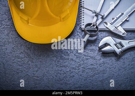 Notebook building helmet compasses vernier scale adjustable spanner construction concept. Stock Photo