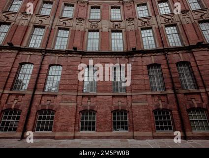 Full frame wide angle view of an imposing Victorian factory building with red brick and rows of ornate window frames and architrave with copy space Stock Photo
