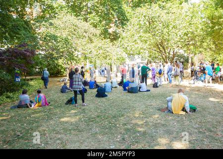 People gather near the cherry tree planted in memory of the victims of Hiroshima during a commemoration event in Tavistock Square, London. Stock Photo